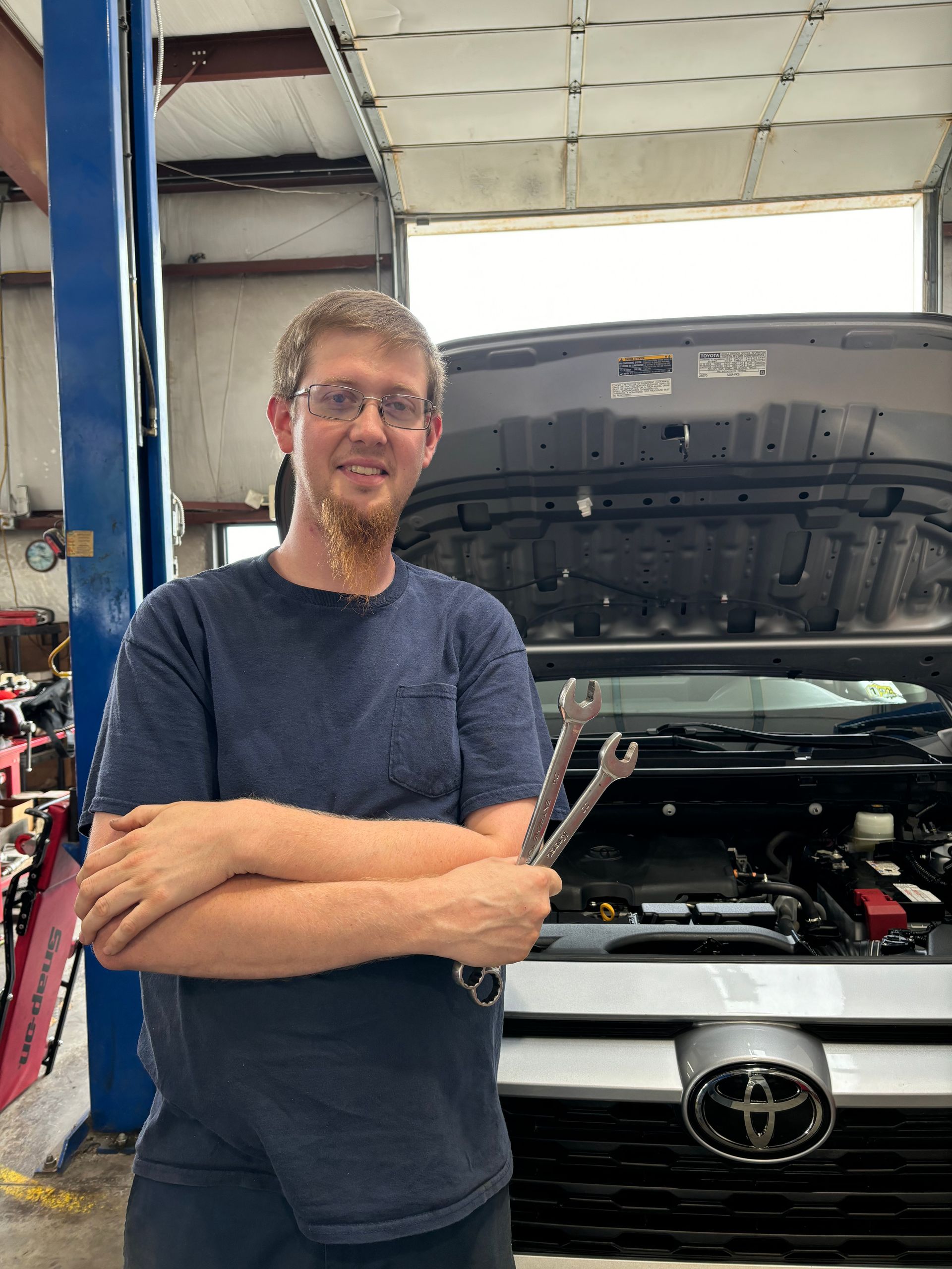Mechanic with crossed arms holding wrenches | Stephen's Automotive
