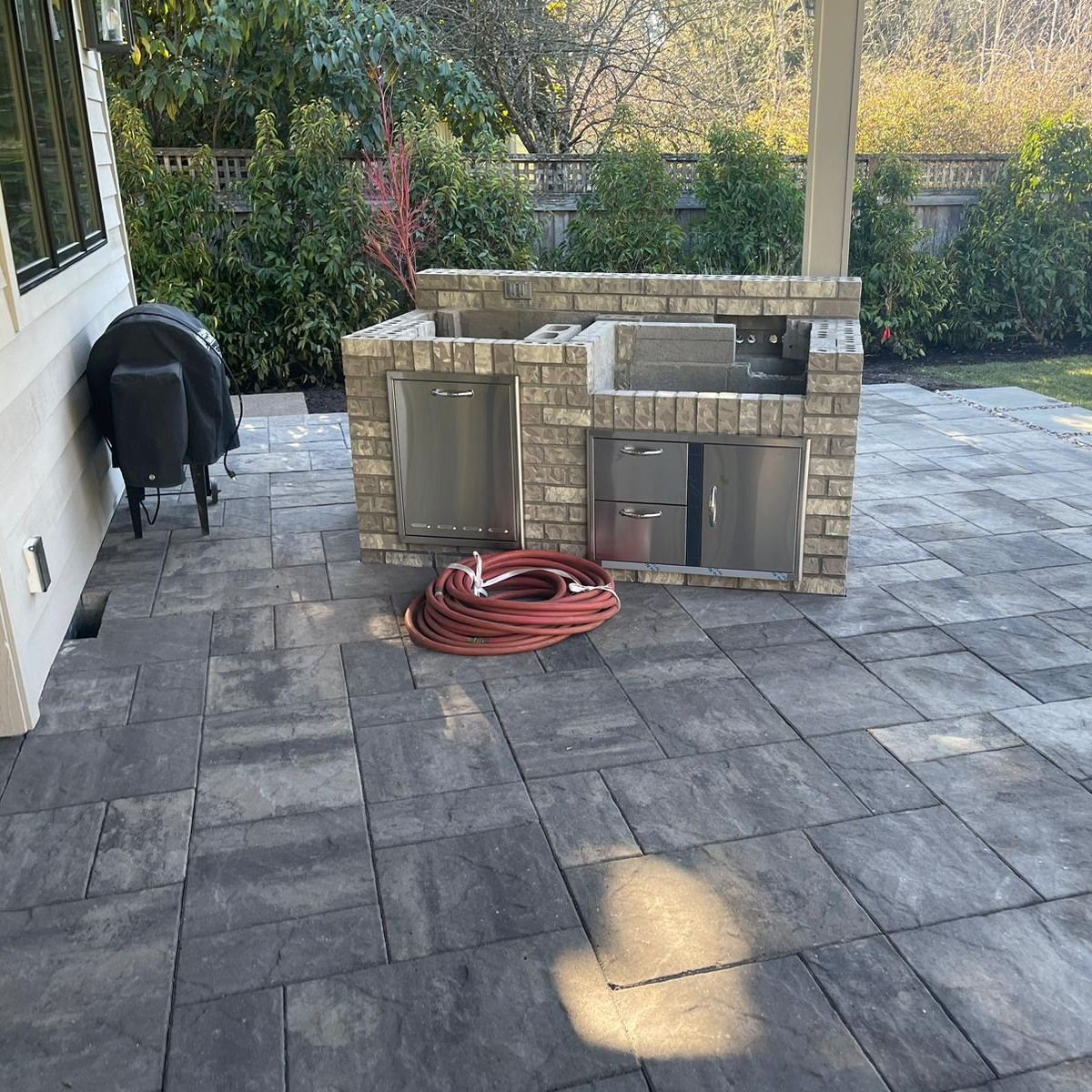 Outdoor patio with a brick grill station and a grill.