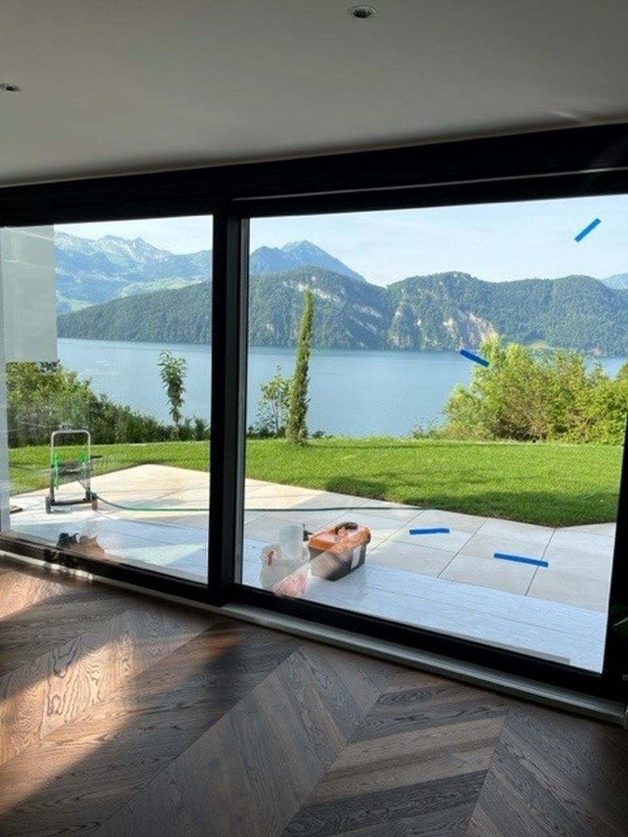 Ein grosses Fenster mit Blick auf See und Berge