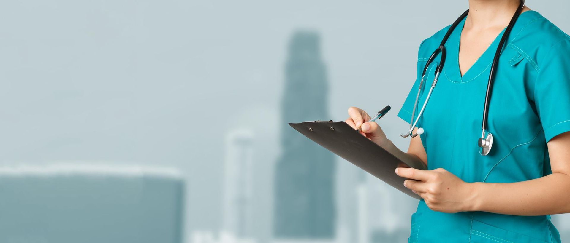 A nurse with a stethoscope around her neck is holding a clipboard.