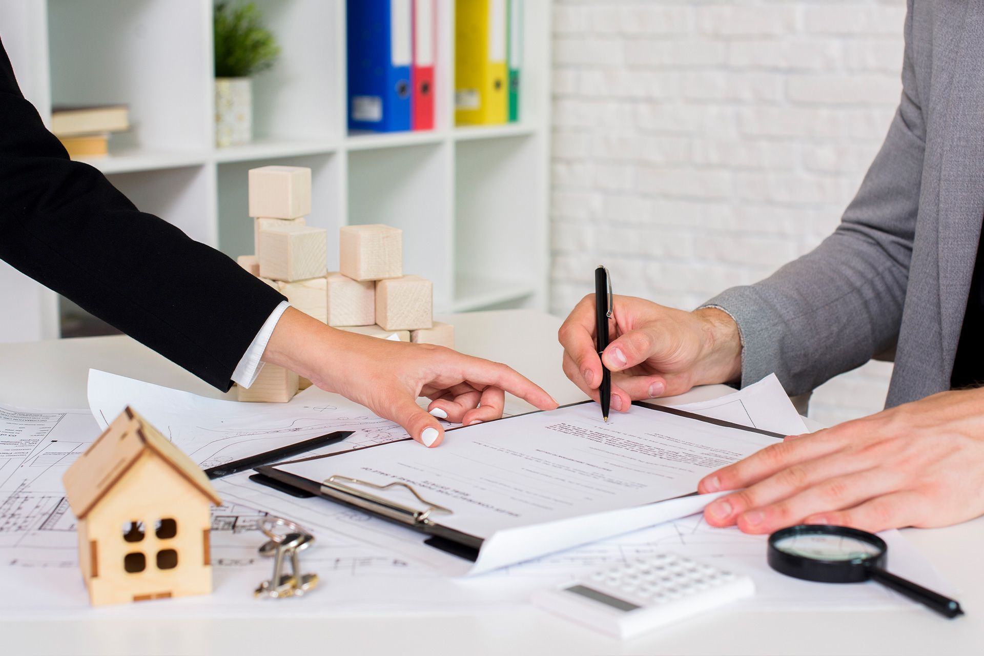 Two people signing Home Inspection Insurance documents at a desk