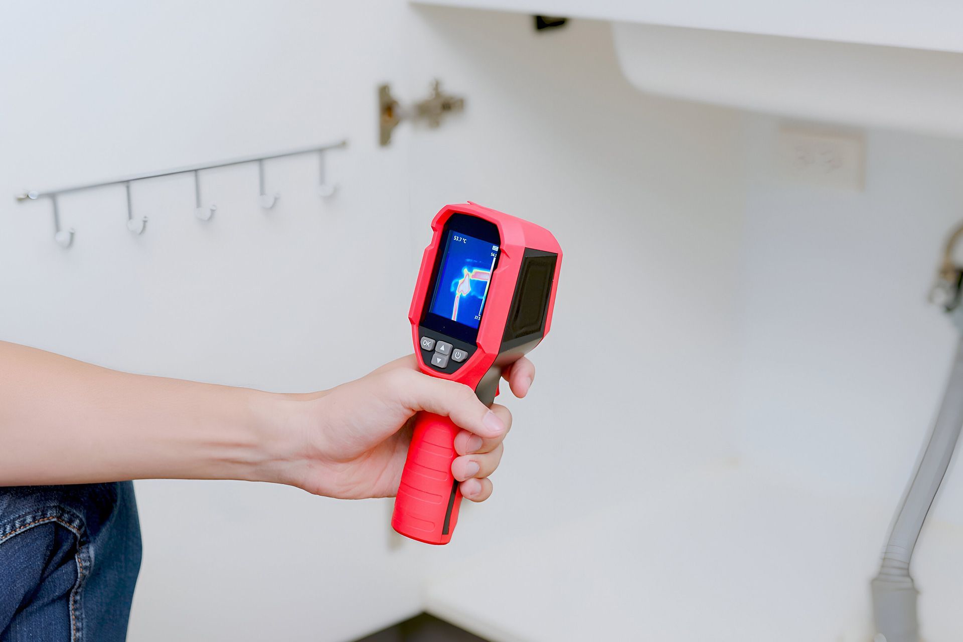 The inspector is using a thermal camera for moisture.