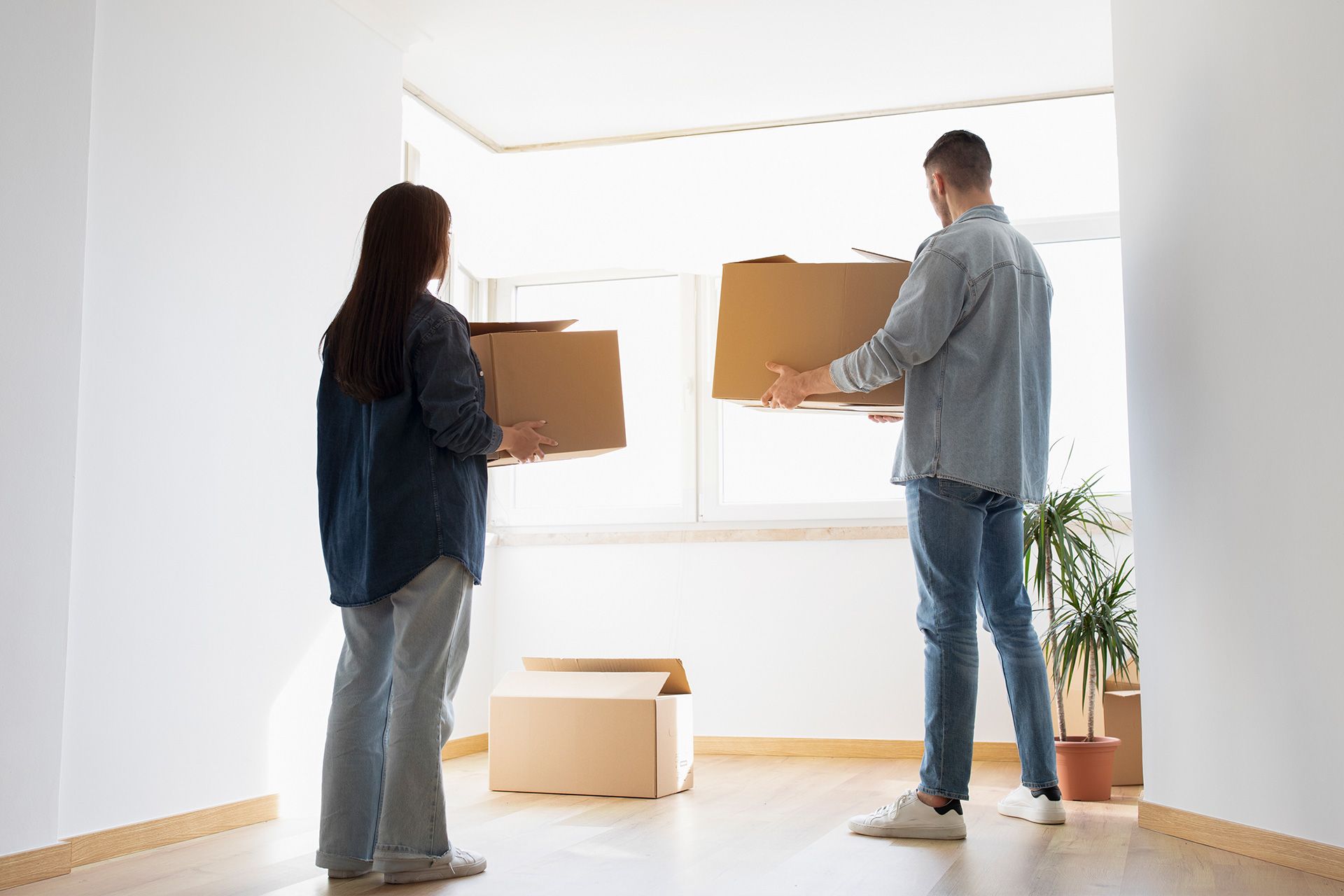 Two people unpacking cardboard boxes in a new construction home in Michigan