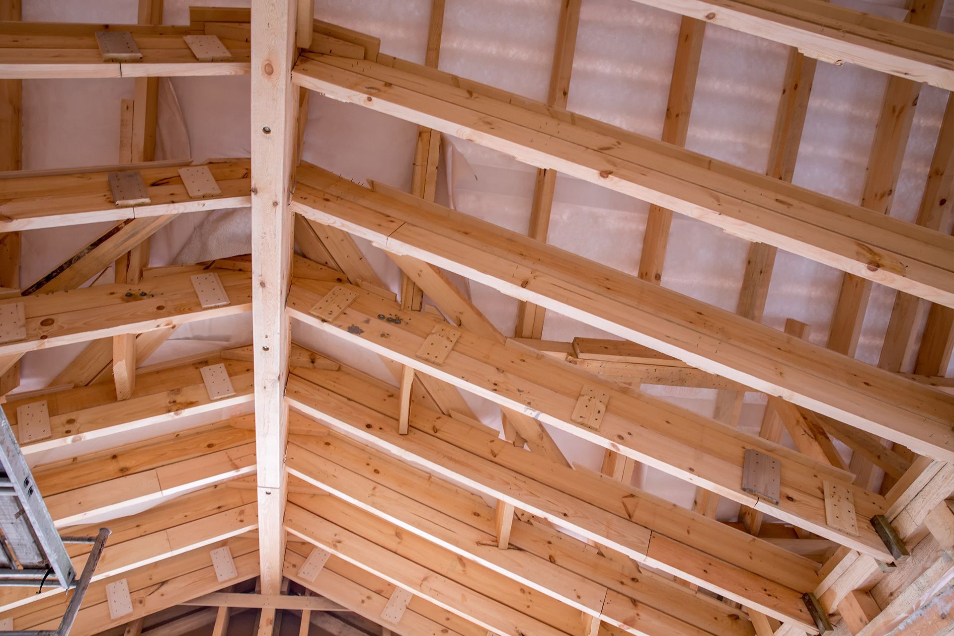 Home inspector checking ceiling joists in a Michigan attic during a detailed home inspection