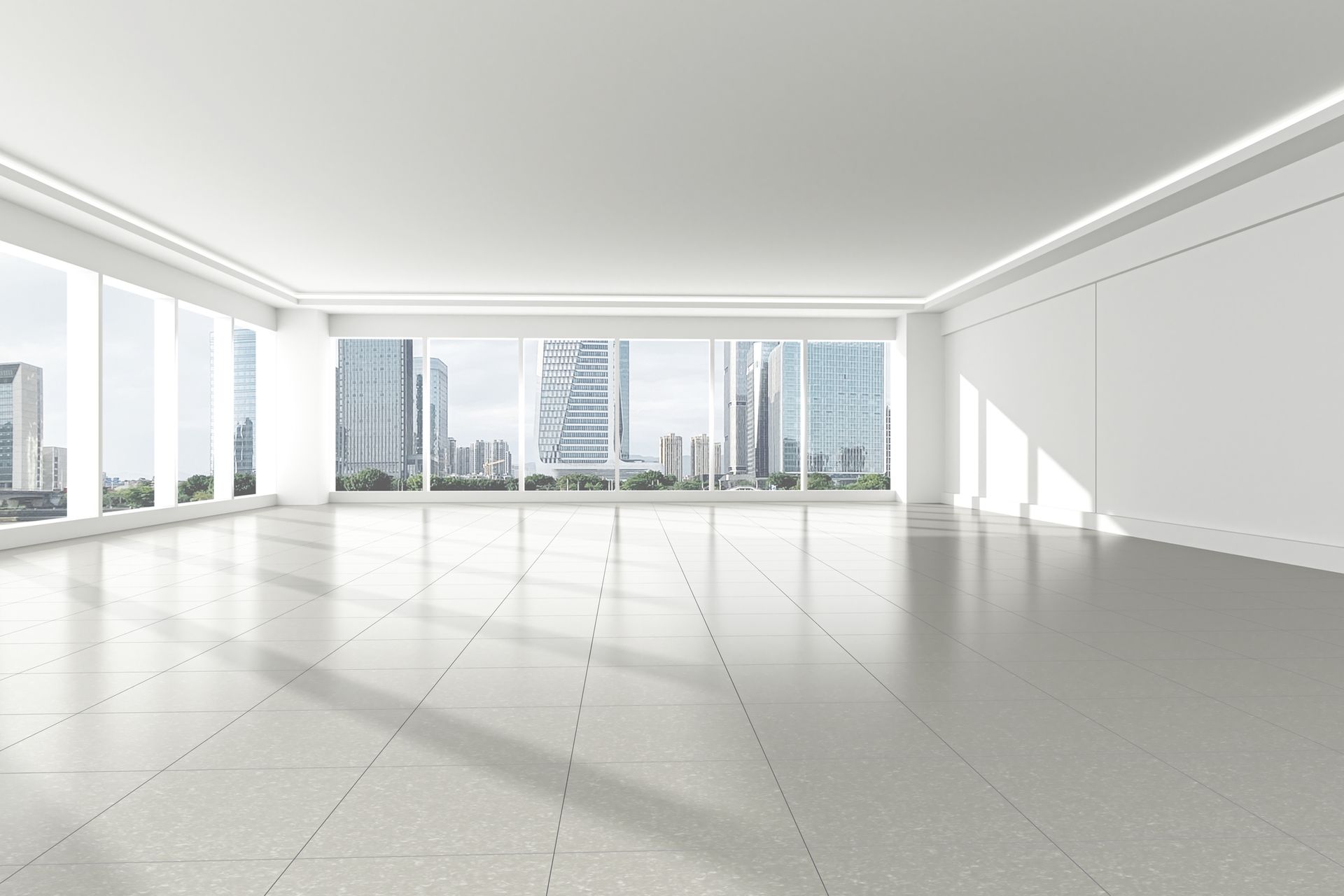 Empty, modern, bright white room with large windows overlooking a city skyline.