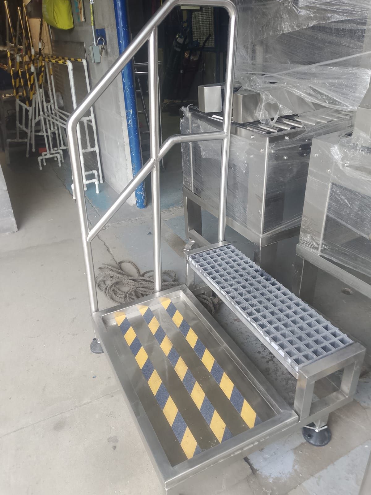 Taburete metálico móvil con franjas de advertencia amarillas