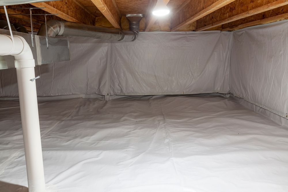 A clean crawl space with white vapor barrier lining the floor and walls, exposed wooden joists, and a white support post.