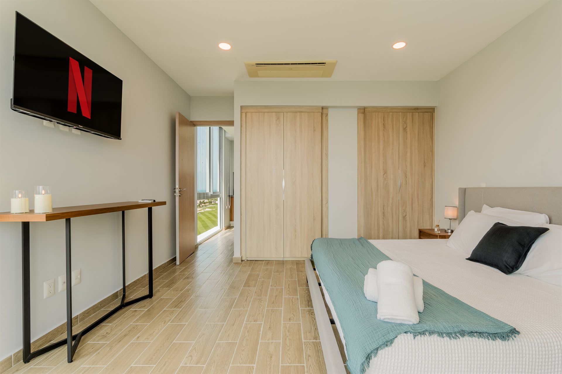 Un dormitorio con una cama grande y un televisor de pantalla plana en la pared.