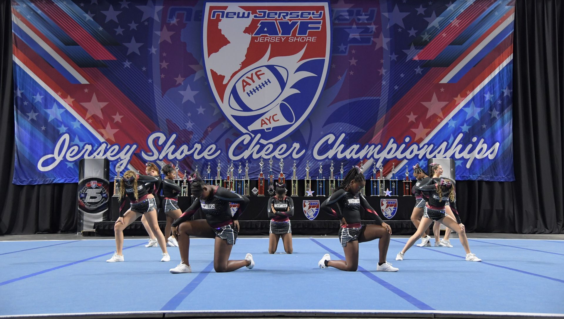 Red, white, and blue pom-poms held high by cheerleaders during a performance.