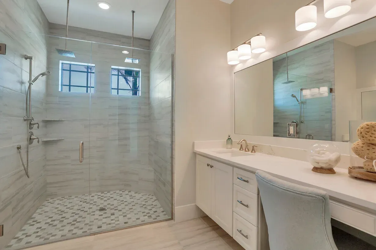 Bright modern bathroom with a glass walk-in shower and double vanity with mirrors.
