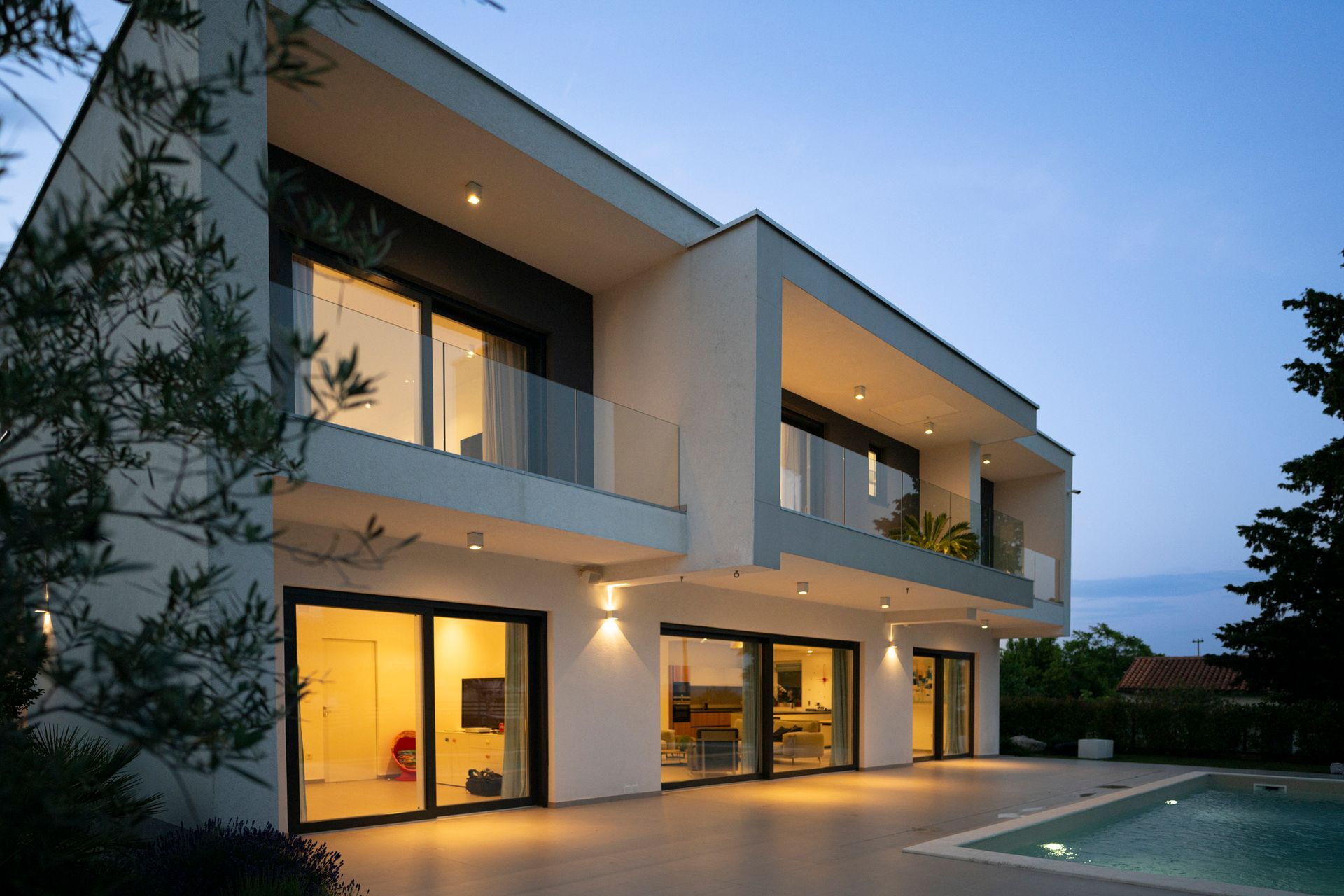 Modern luxury home exterior with pool, featuring updated residential electrical systems. 