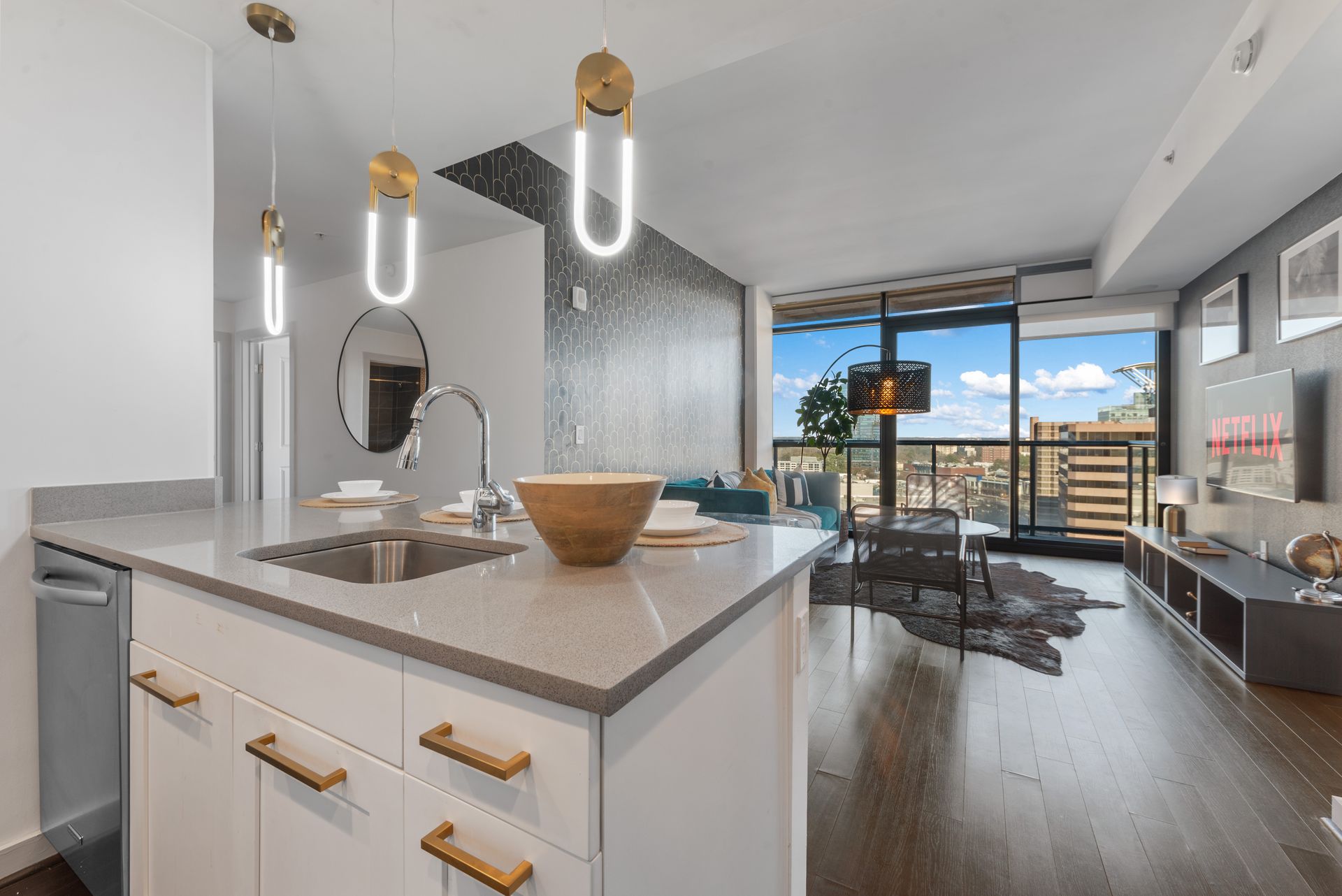 Beautiful kitchen island looking into the living room which features floor to ceiling windows.