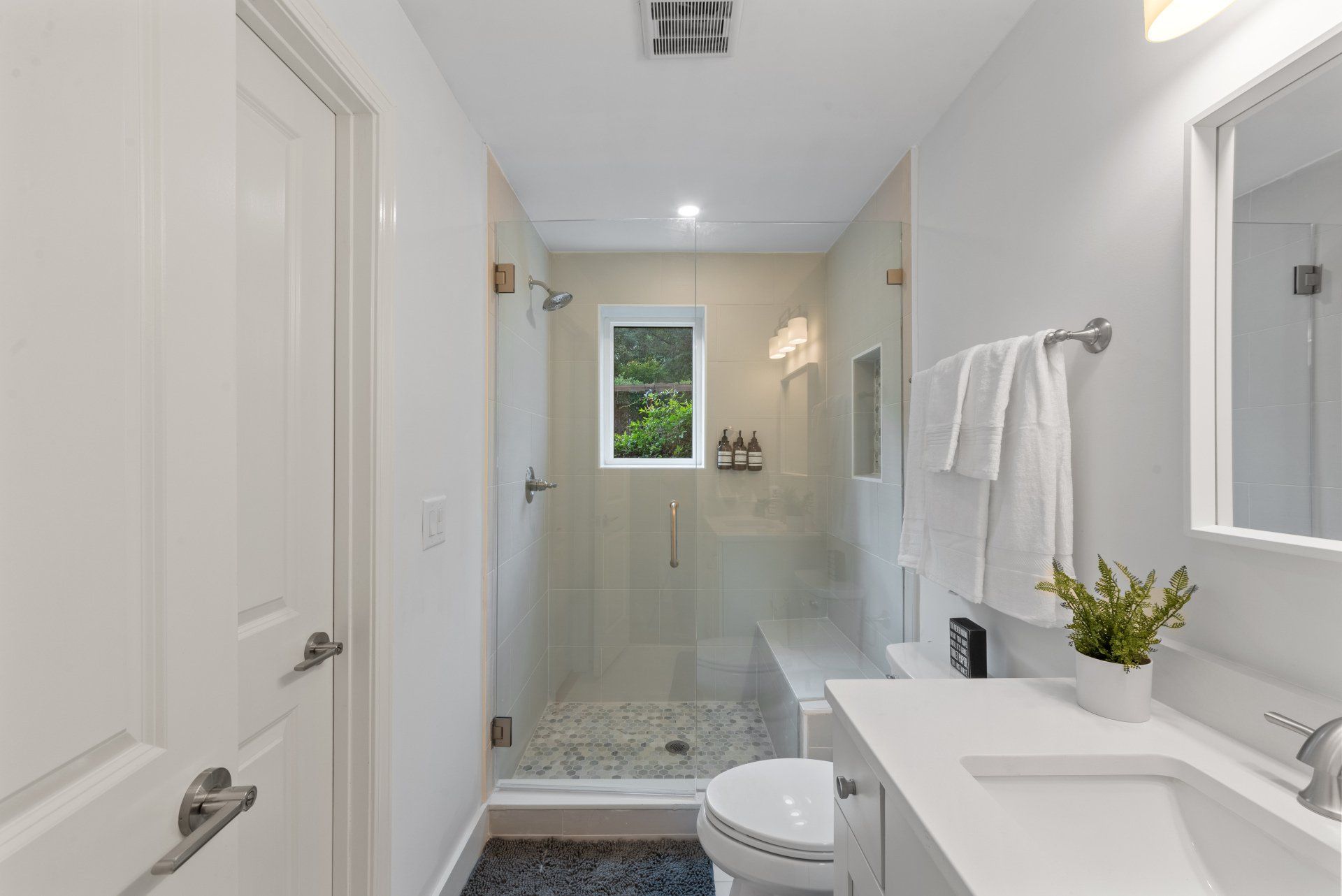 Modern white bathroom with shower, toilet, and vanity.