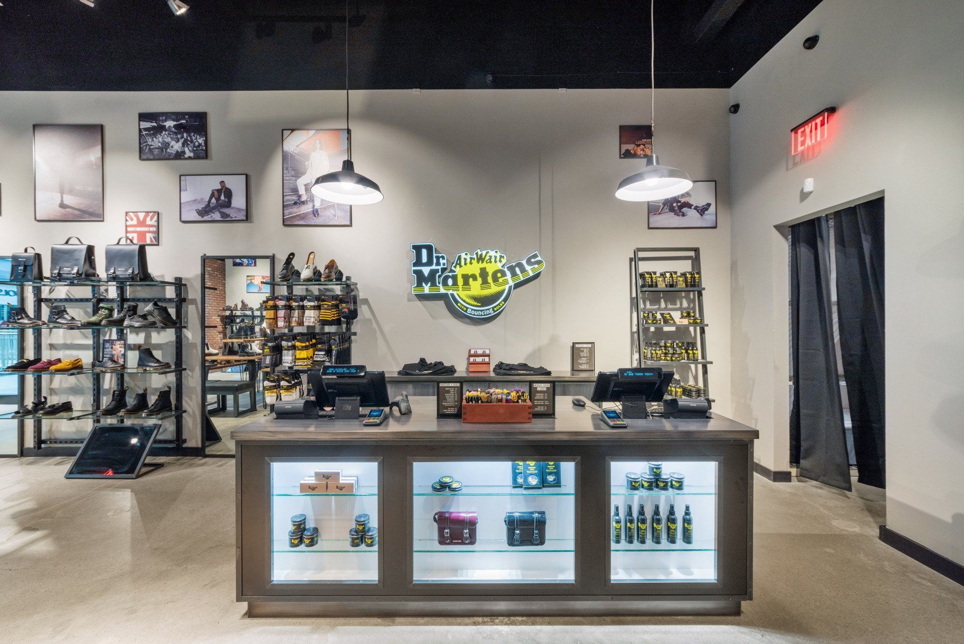 Dr. Martens store interior with shoes displayed on shelves, a central counter, and branded logo.