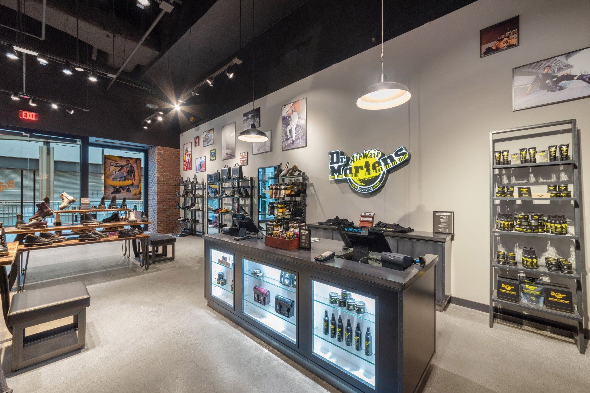 Interior of a Dr. Martens store: shoes on display, cash register, shelves, and posters on walls.