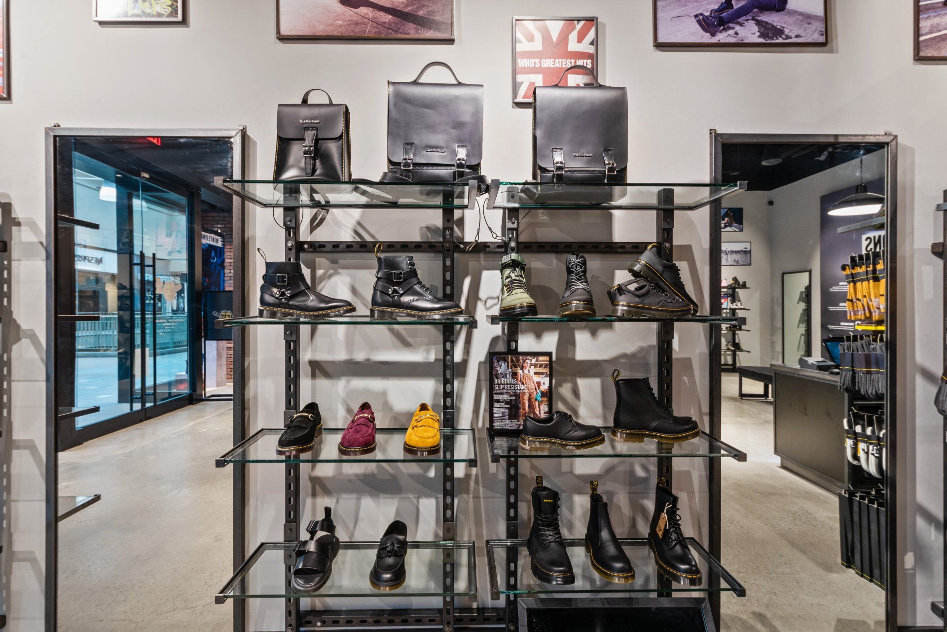Interior of a Dr. Martens store with boots and bags displayed on metal shelves.