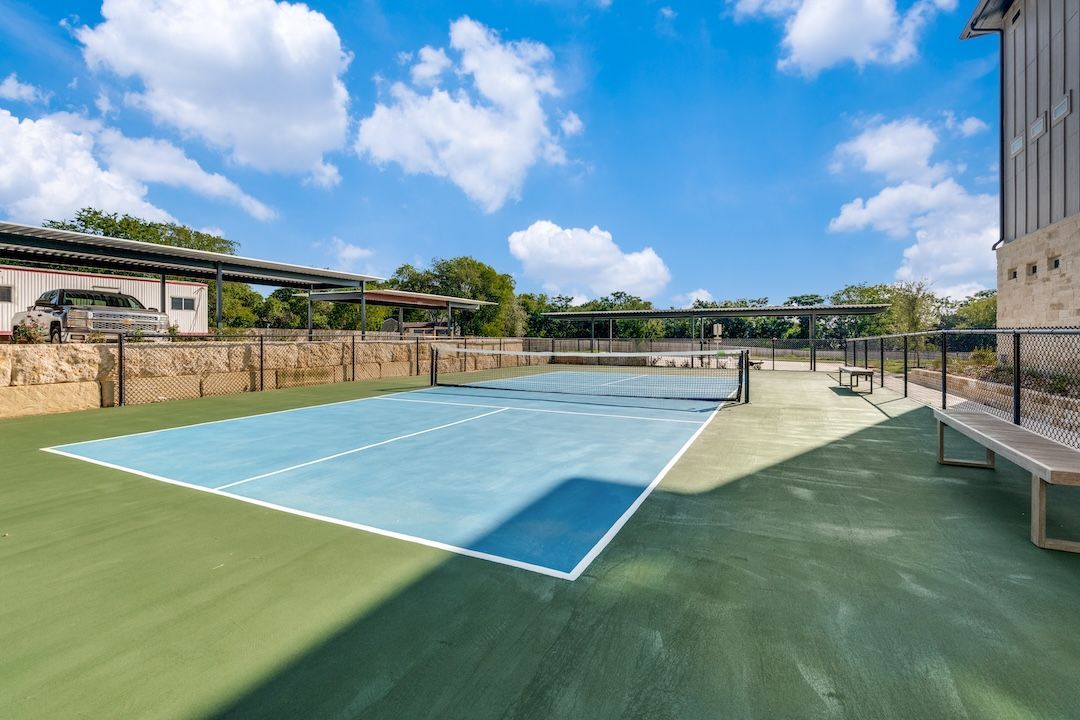 Empty outdoor swimming pool with blue lanes beside a building under a bright sky