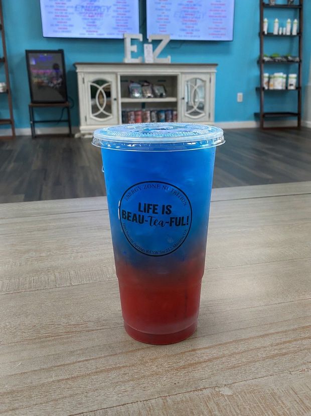 Loaded teas and energy drinks served on a bright nutrition counter with fruit garnishes.