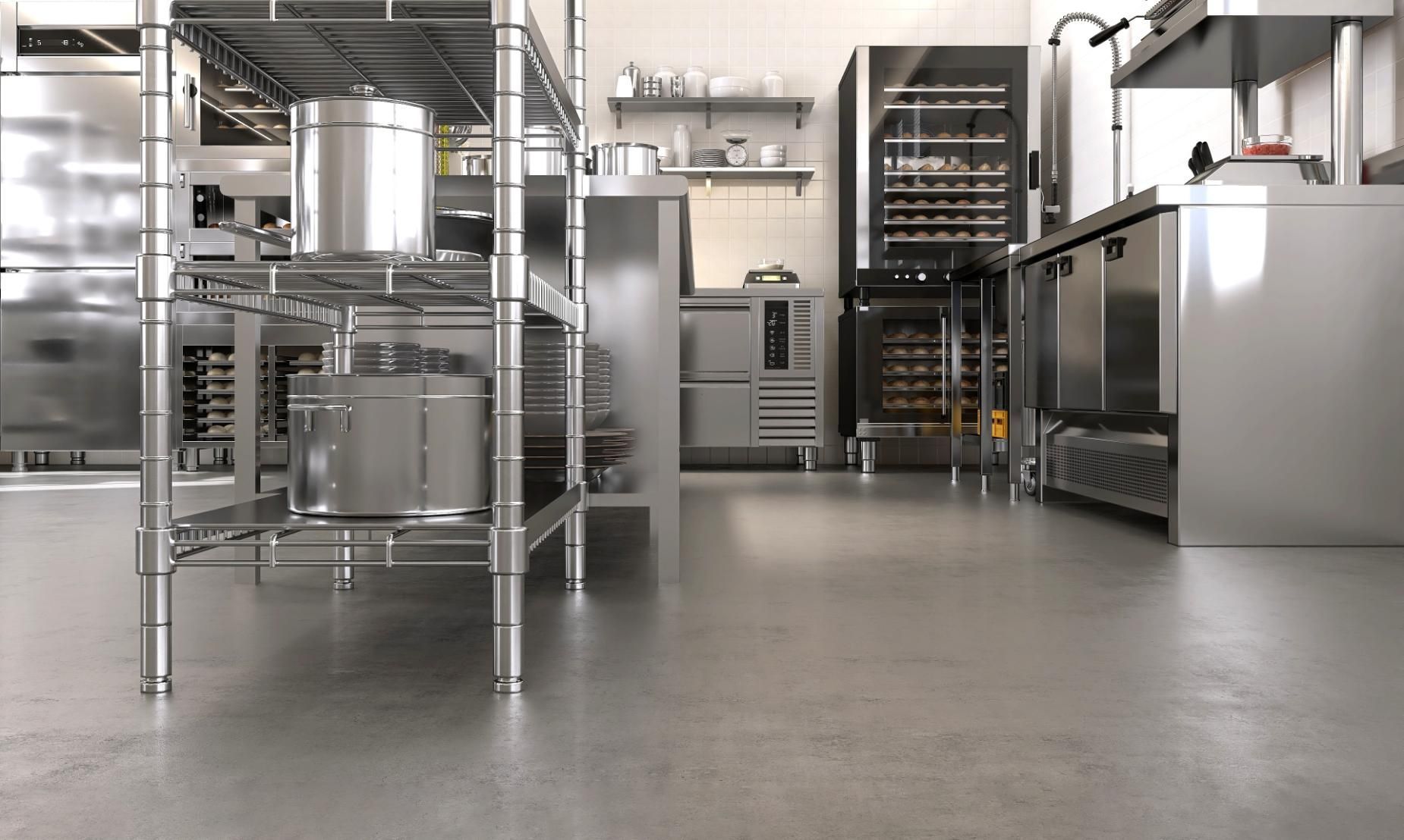 A modern professional kitchen with stainless steel workstations, wire shelving units, and industrial appliances.