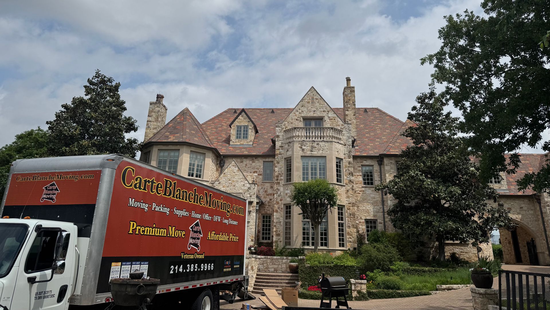 A large stone manor house with a red and black 