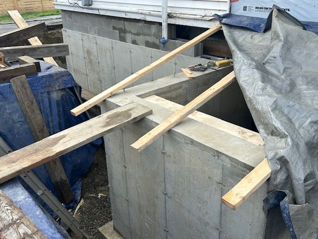 A concrete wall is being built with wooden beams