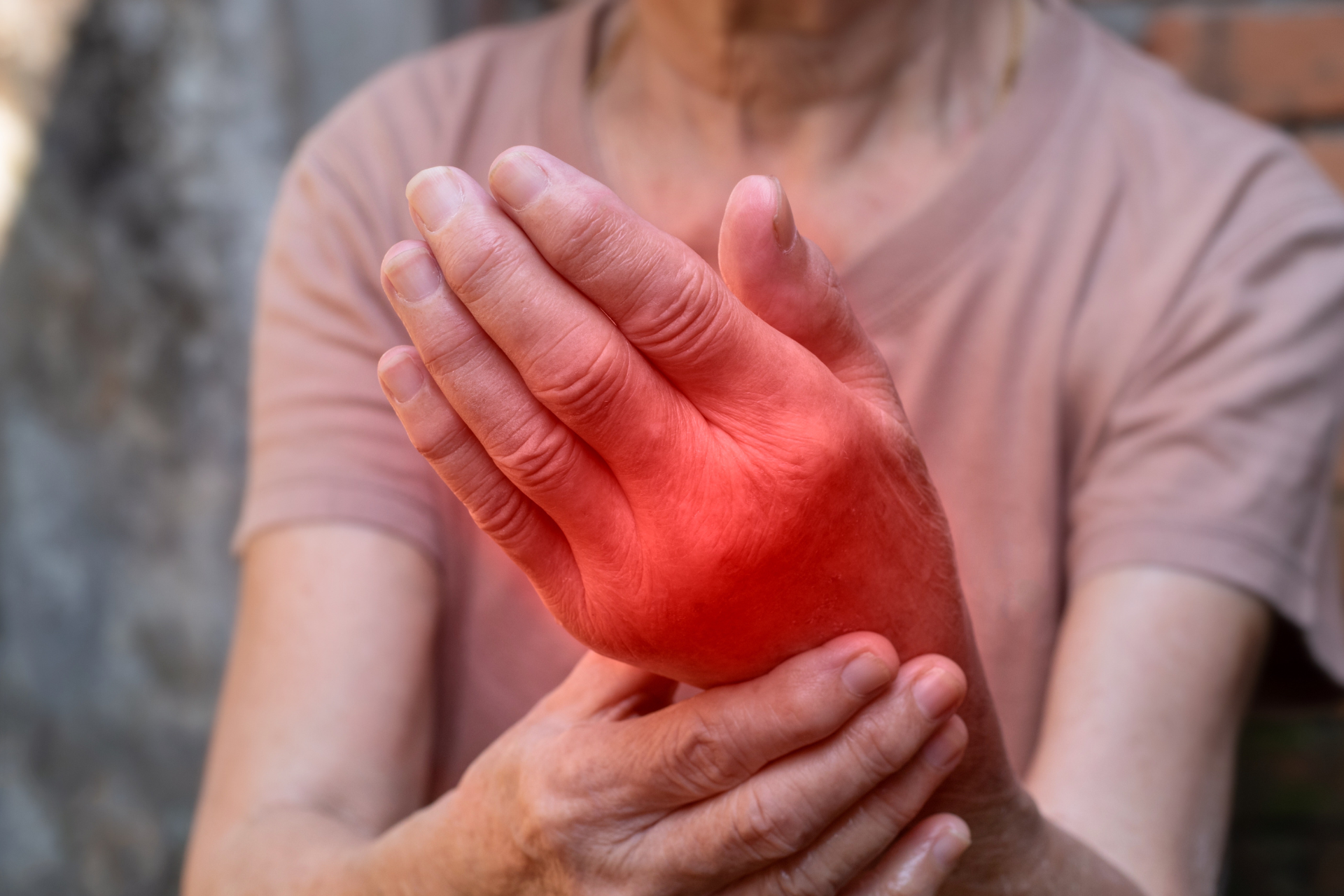 A woman is holding her hand in pain.