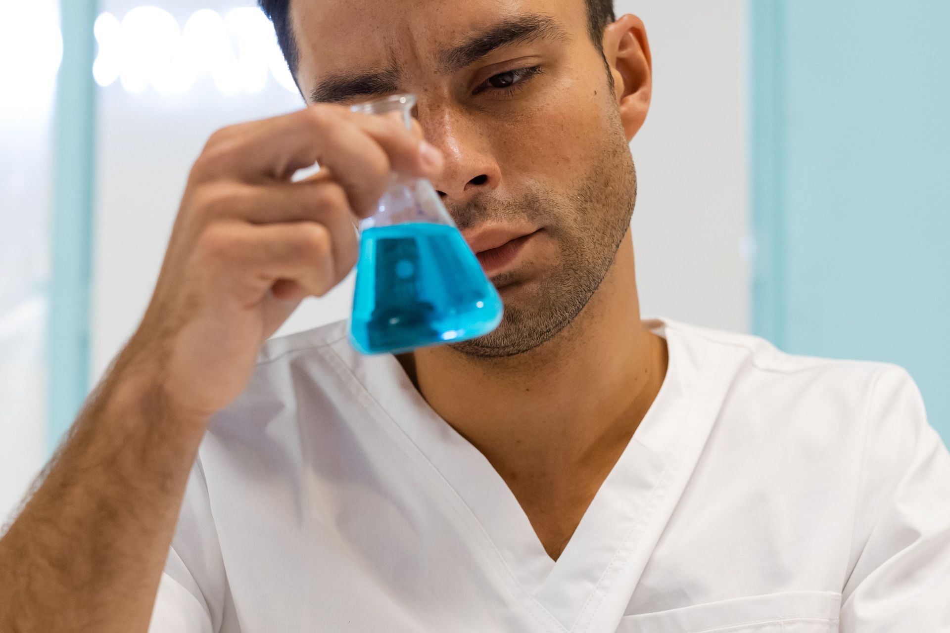 A person is holding a blue pen next to a box that says ' xnos ' on it