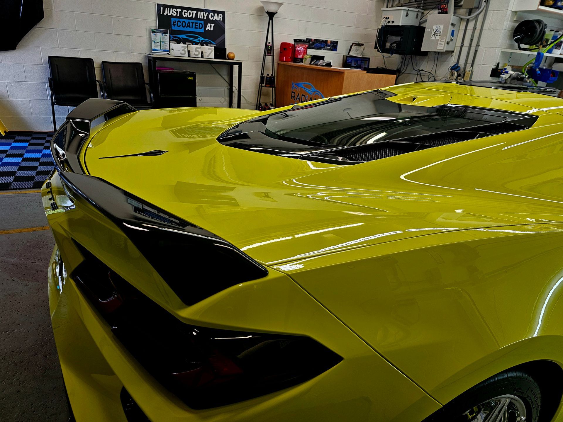 A yellow sports car is parked in a garage