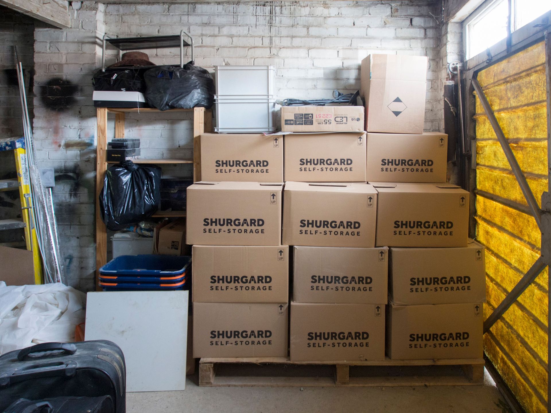 Storage container filled with sofas, mattresses, toolboxes, and stacked boxes