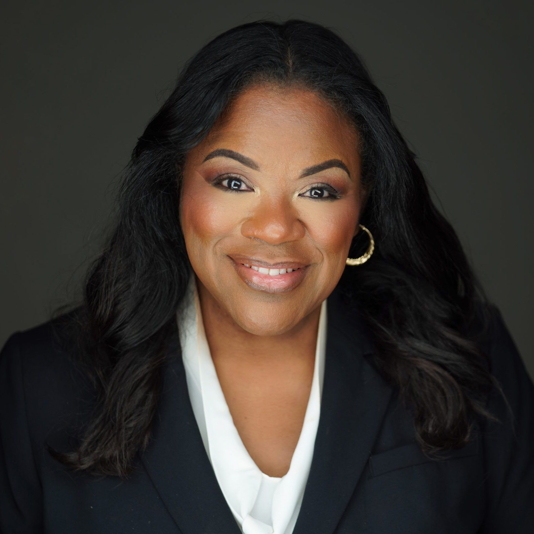 Lisa Wogwu in a black blazer and white blouse against a dark background