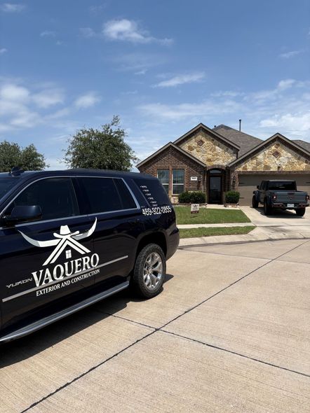 Black Vaquero Security SUV parked in a suburban driveway in front of a brick house.