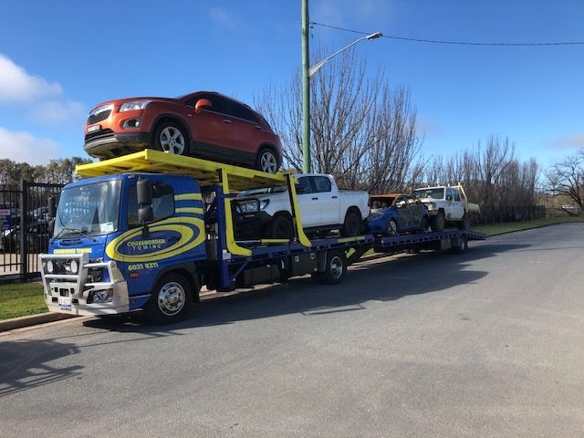 A Tow Truck is Towing a Car on the Highway — Crossborder Towing in Albury, NSW