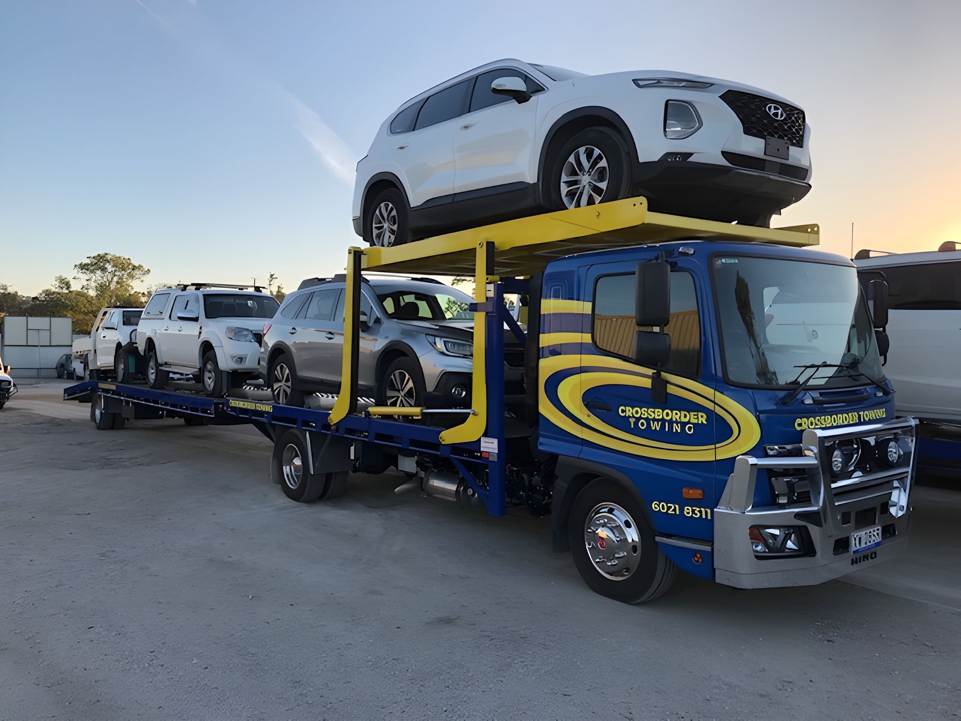 A Tow Truck is Carrying a Bunch of Cars on Top of It — Crossborder Towing in Baranduda, VIC
