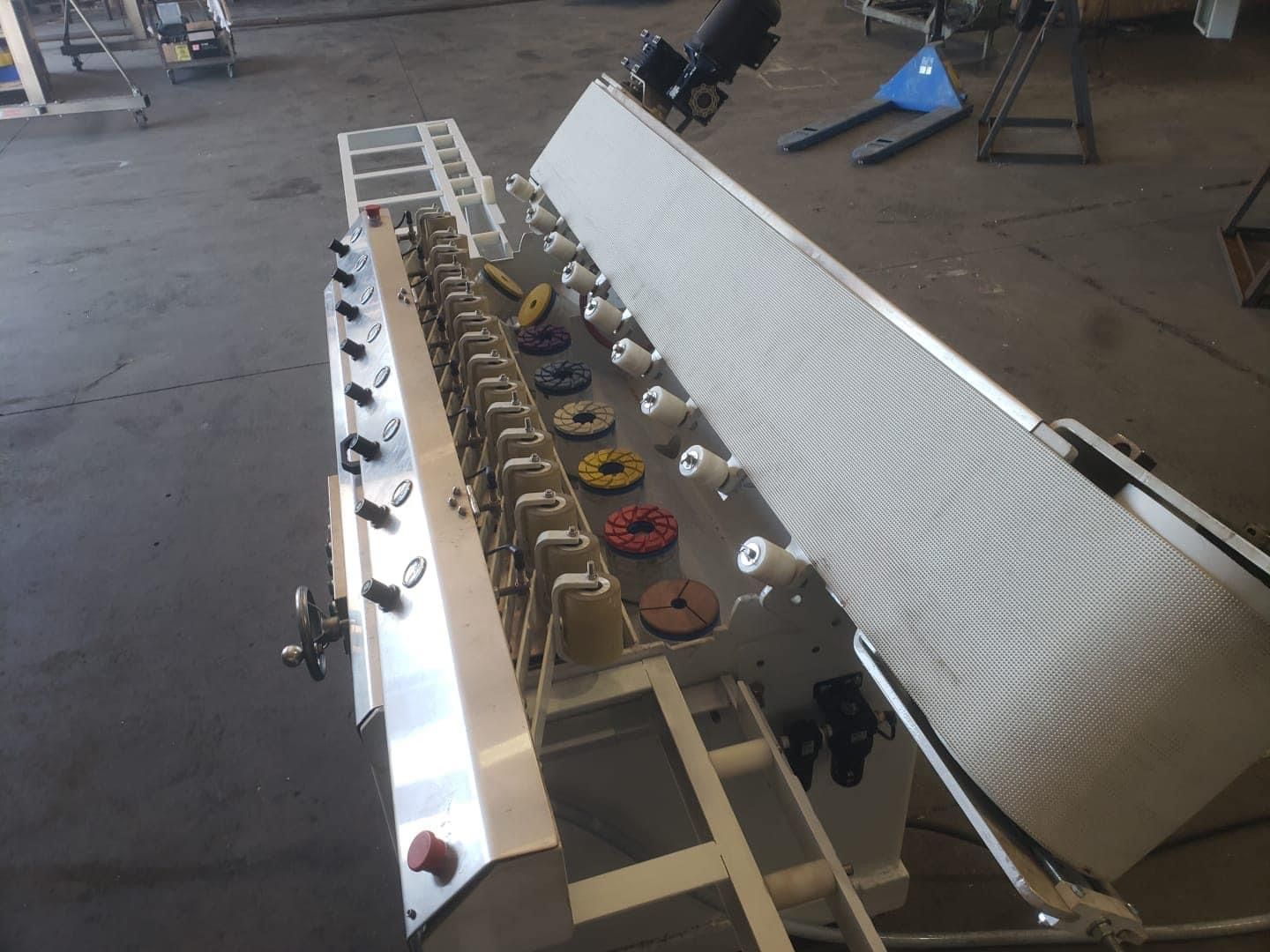 Large, white, rectangular industrial table with a metal surface, on a concrete floor.