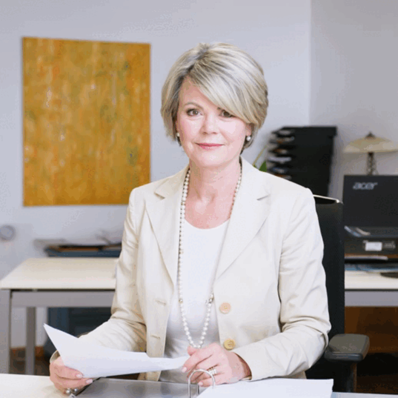 Une femme assise à un bureau avec un ordinateur portable Acer en arrière-plan