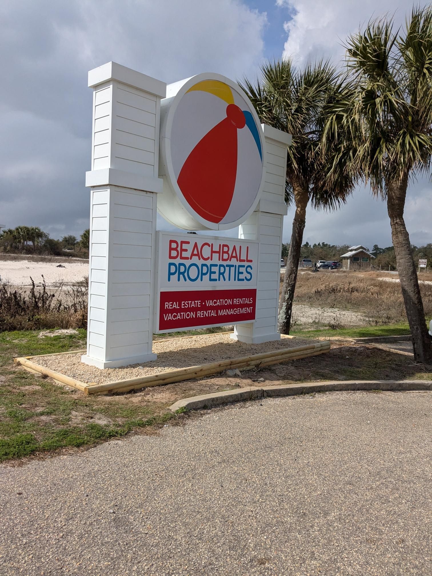 Sign for Beachball Properties with a beach ball logo and white pillars.
