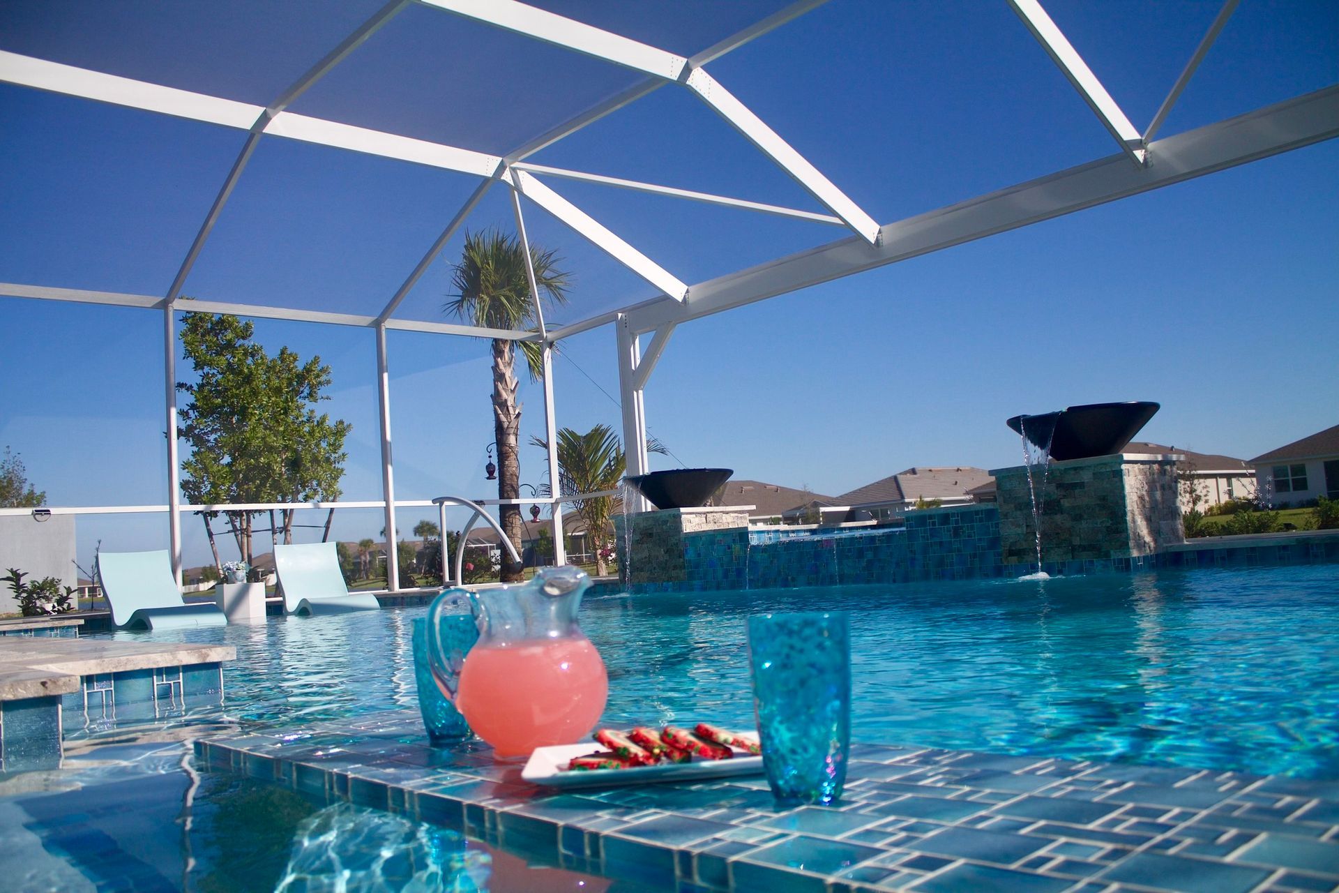 A swimming pool with a pitcher of watermelon juice on the edge