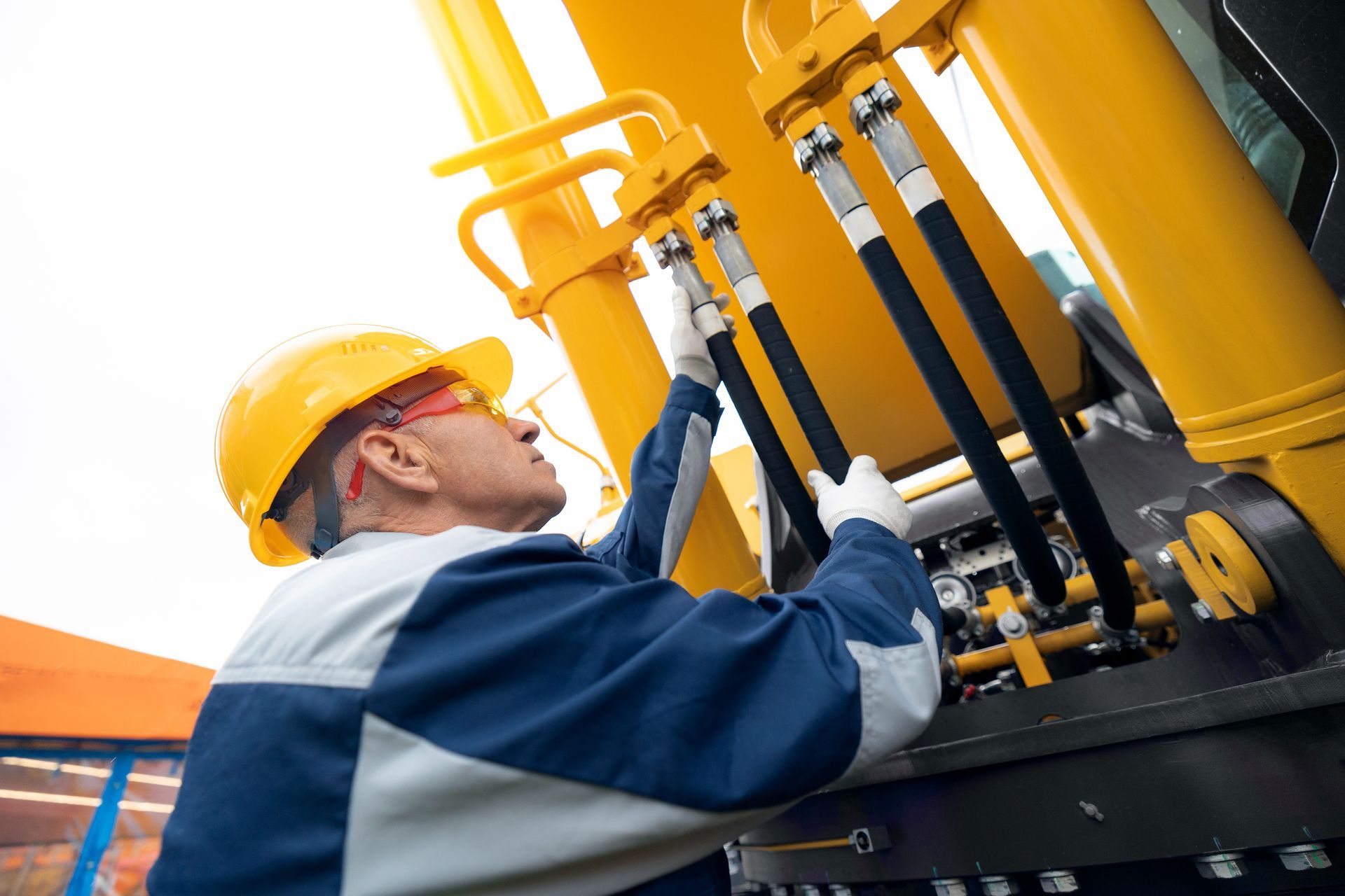 Machinery tractor mechanic checks hydraulic hose system Machinery tractor mechanic checks hydraulic hose system