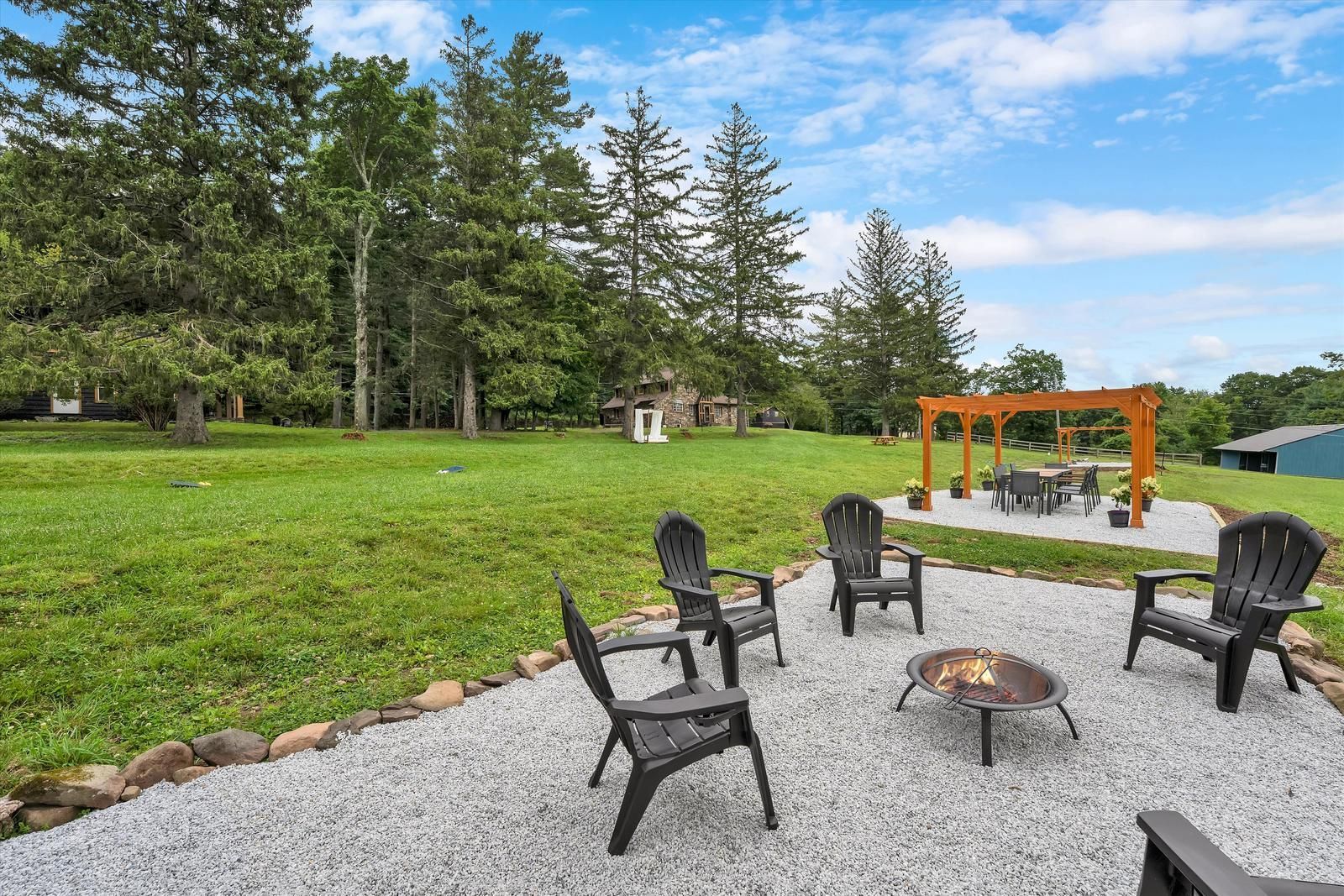 Adirondack chairs around the fire pit on the lawn