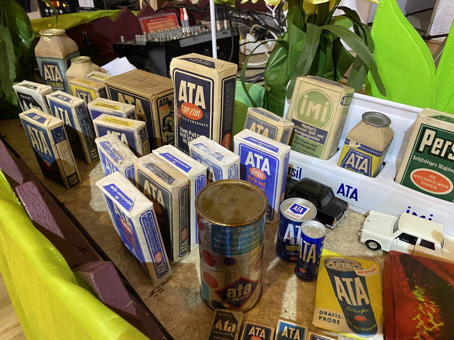 Ausstellung von alten ATA-Reinigungsproduktverpackungen, darunter Schachteln und Dosen, auf einem Tisch.