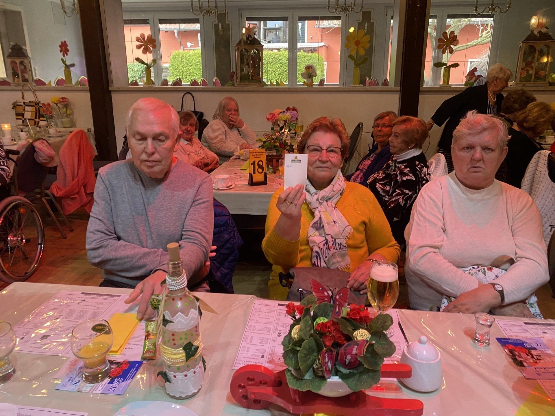 Gruppe von Menschen an einem Tisch in einem Restaurant. Frau hält eine Karte; andere schauen zu.