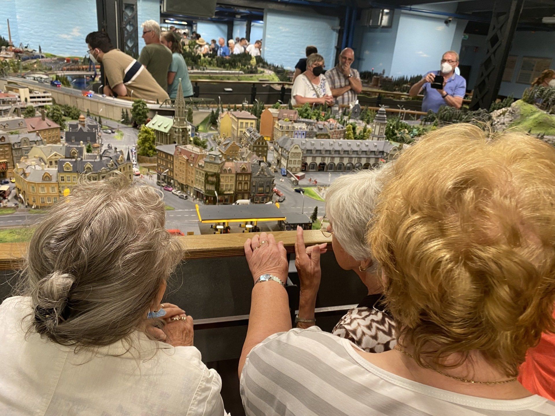 Menschen betrachten ein detailliertes Miniatur-Eisenbahn-Diorama.
