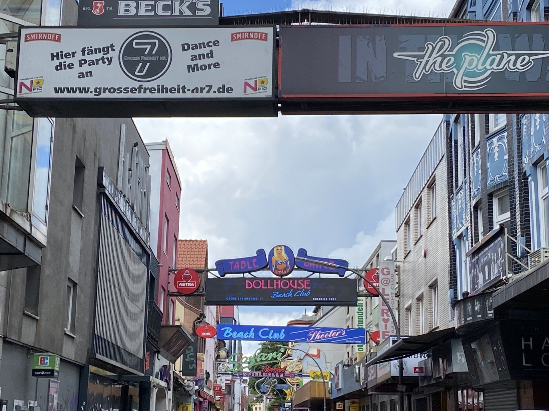 Straßenszene mit Neonschildern für Bars und Clubs in einer europäischen Stadt.