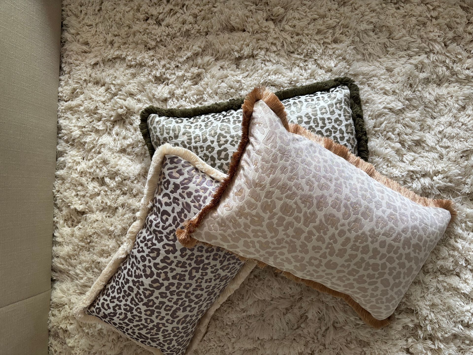 Rechthoekig decoratief kussen met luipaardprint en beige rand op een witte achtergrond.
