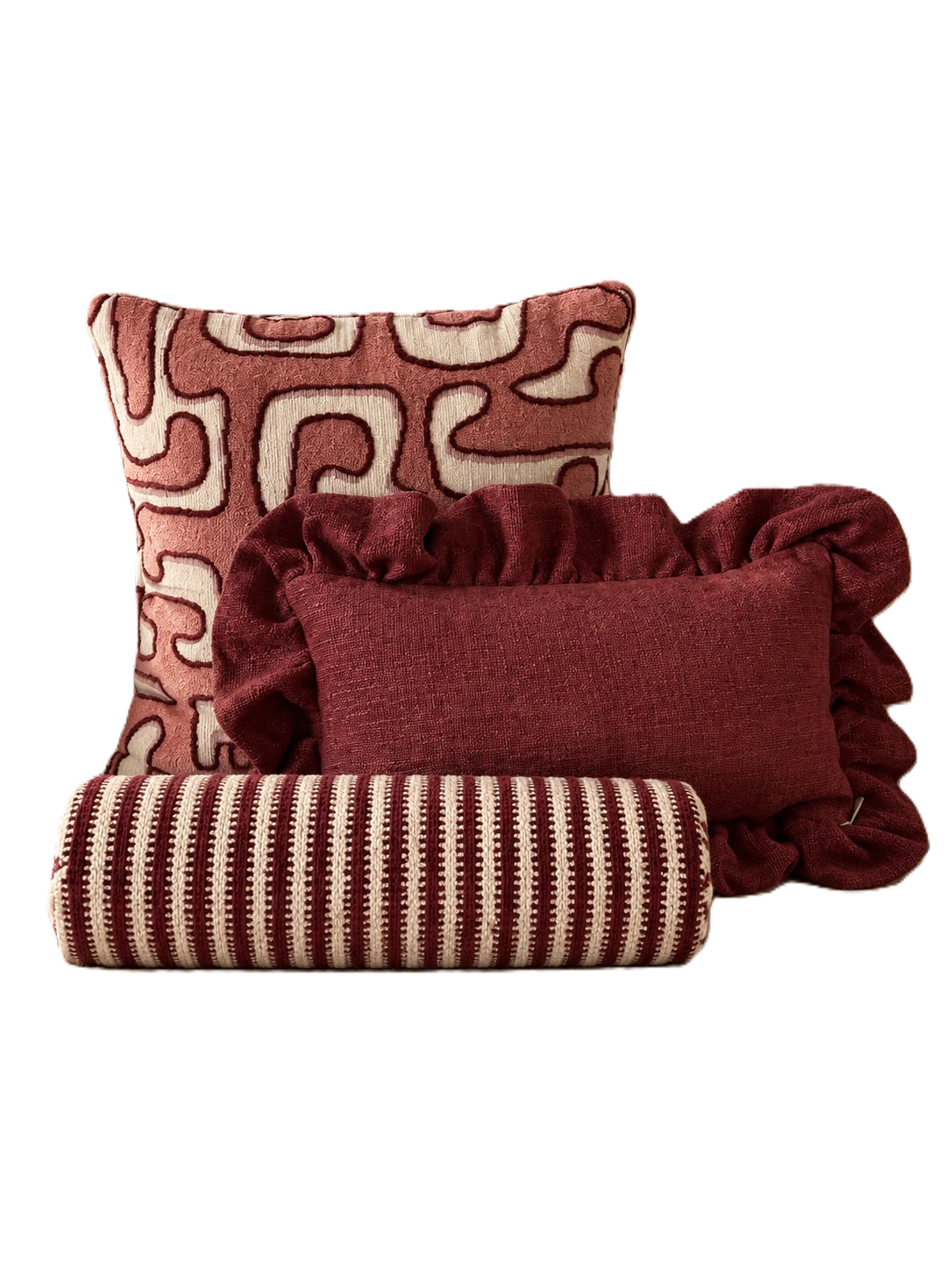 Drie decoratieve sierkussens in rood en crème met verschillende patronen, opgestapeld