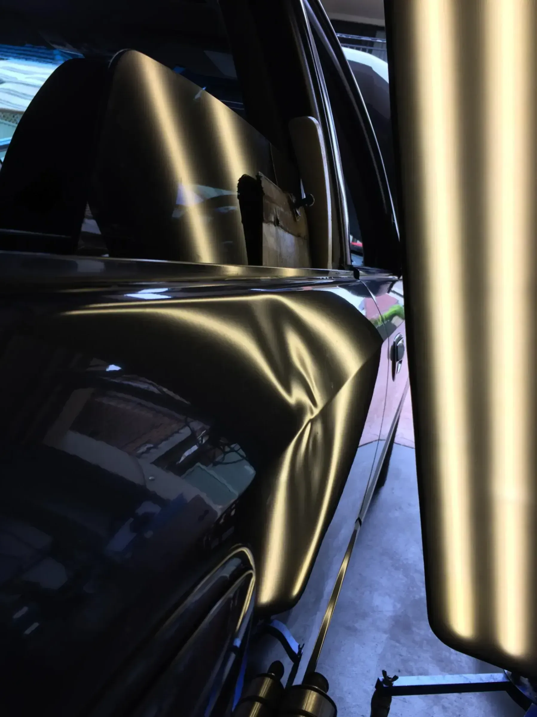 A black car with a large dent on the side of it