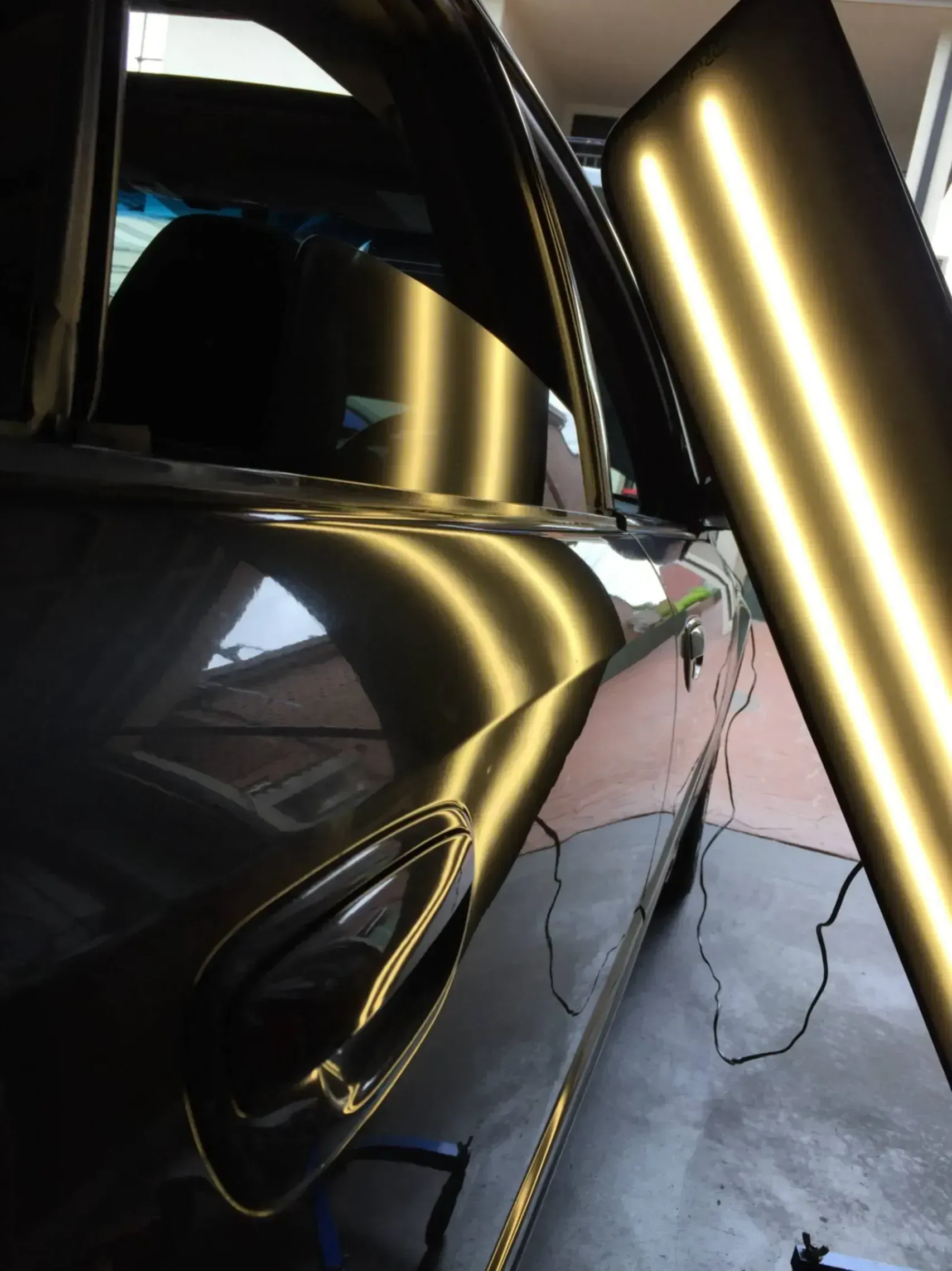 A car with a dent in the door is being repaired.