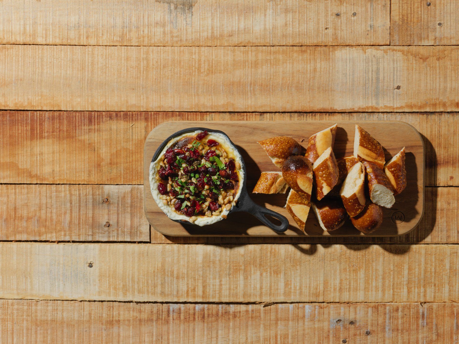 Bread and dip on a wooden tray in bright sunlight