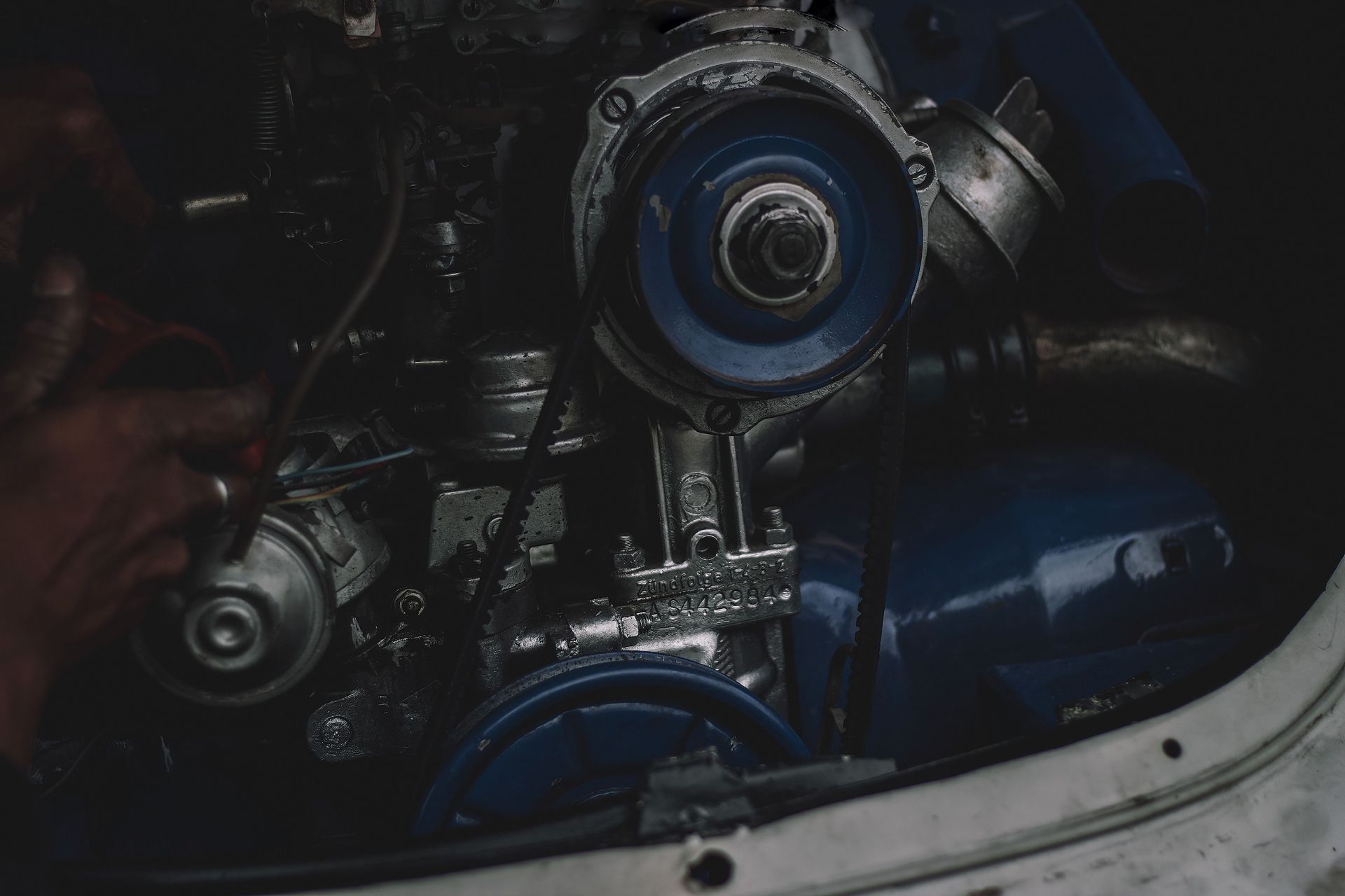 Close-up of a dark blue engine or machinery with metal components inside a compartment