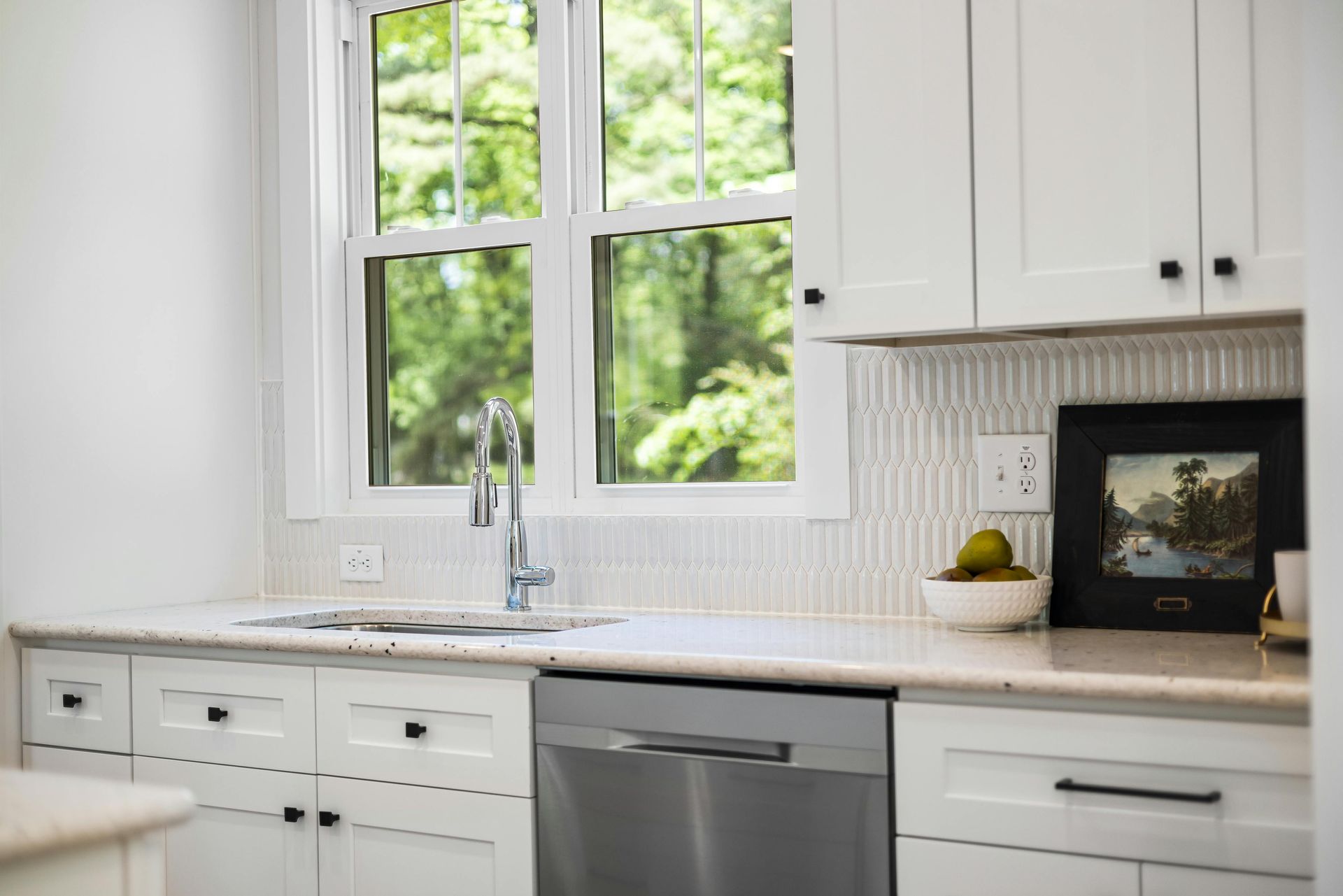 A kitchen with a sink , microwave , and a clock on the wall.